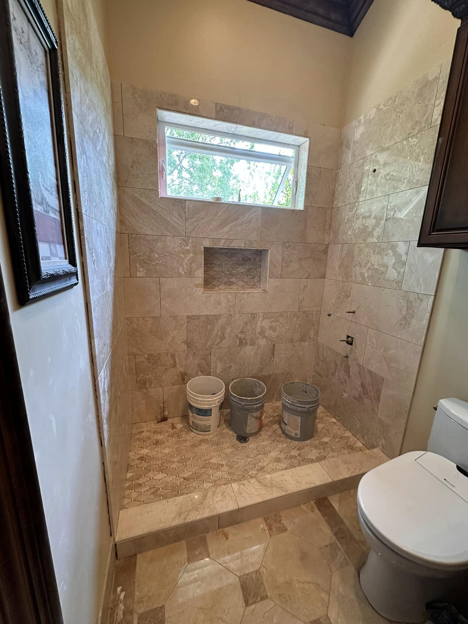 Shower remodel with marble herringbone tile